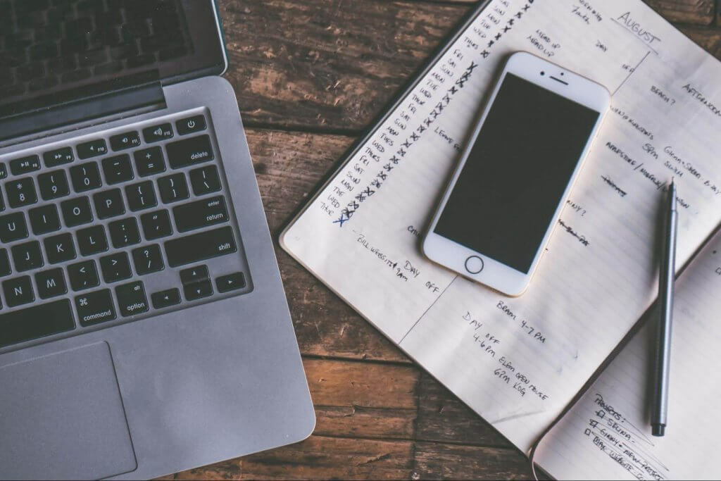 a notebook, and a mobile phone on a desk