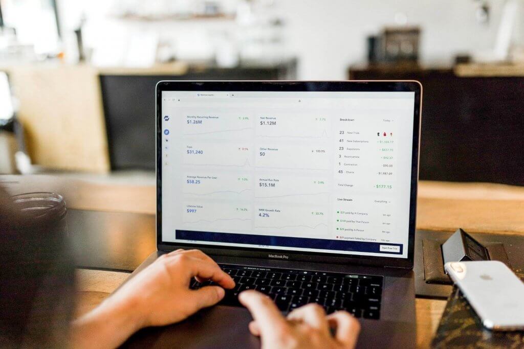 Someone using their Mac Book Pro. Decluttering Your Finances